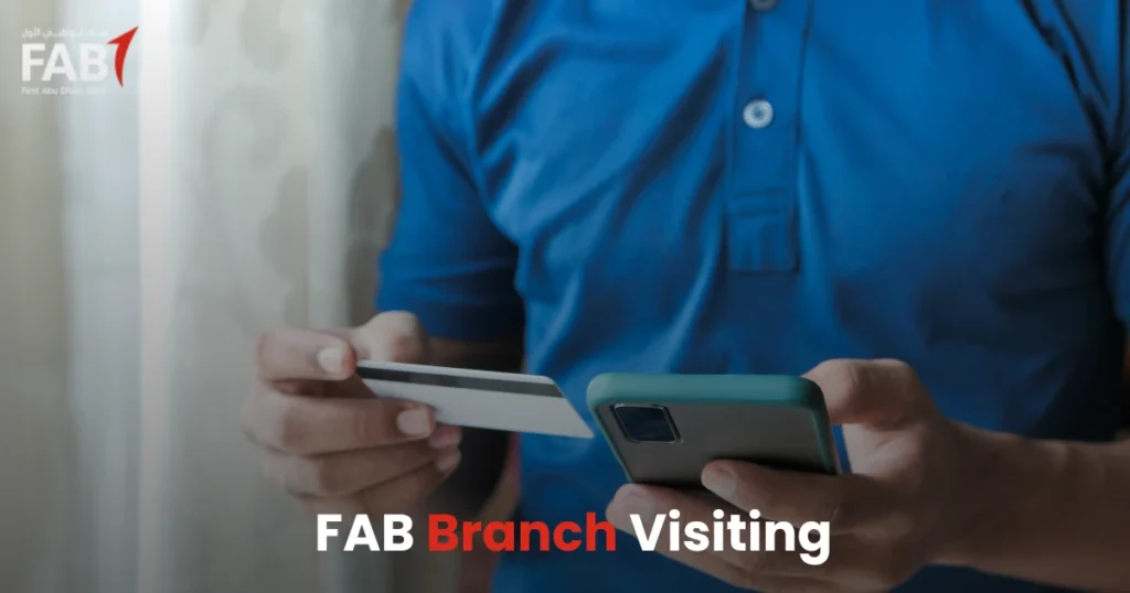 Customer visiting FAB Bank branch to check salary account balance with debit card and mobile phone